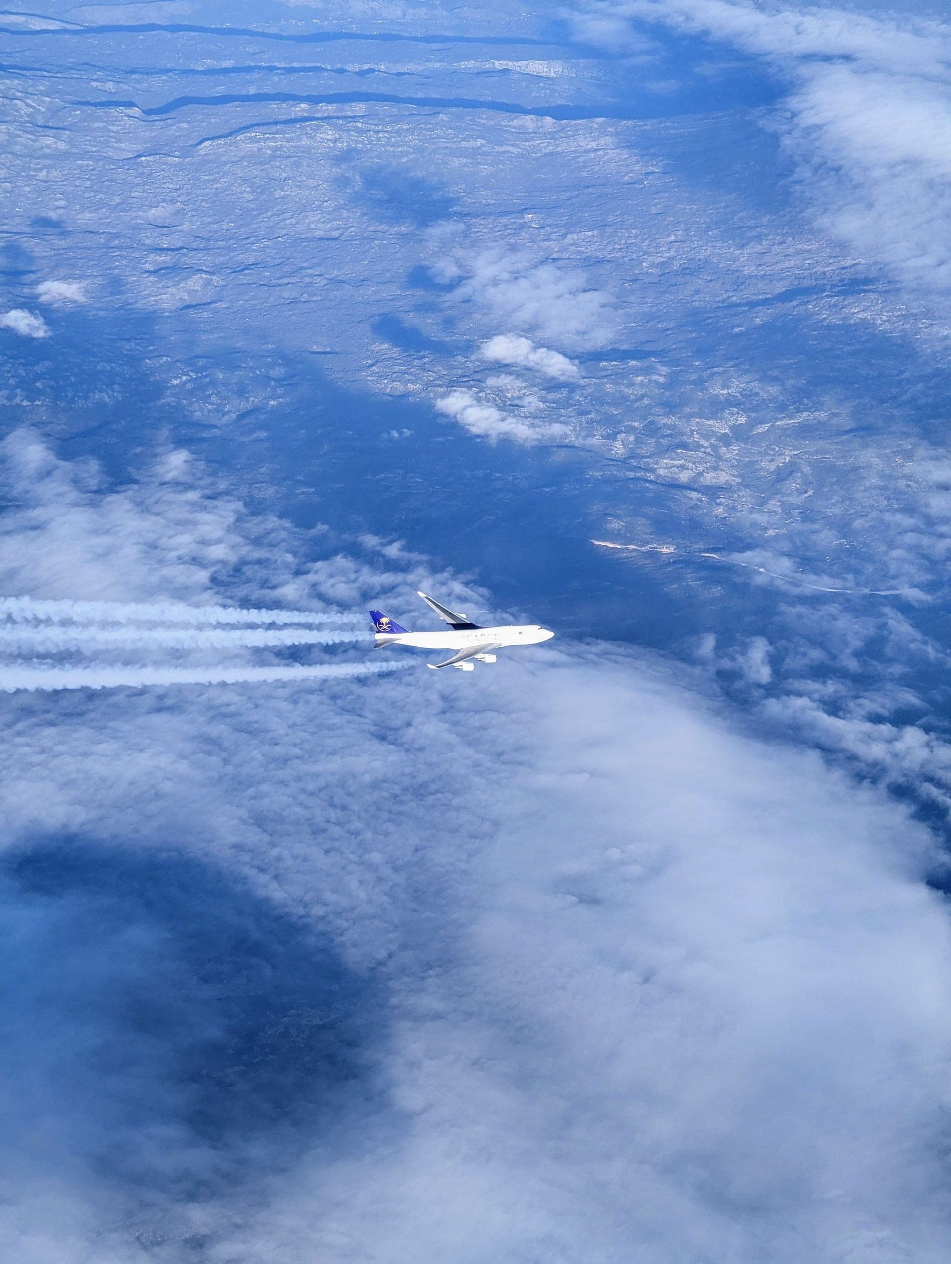 Commercial airliner cruising above the clouds, representing international travel and global connections